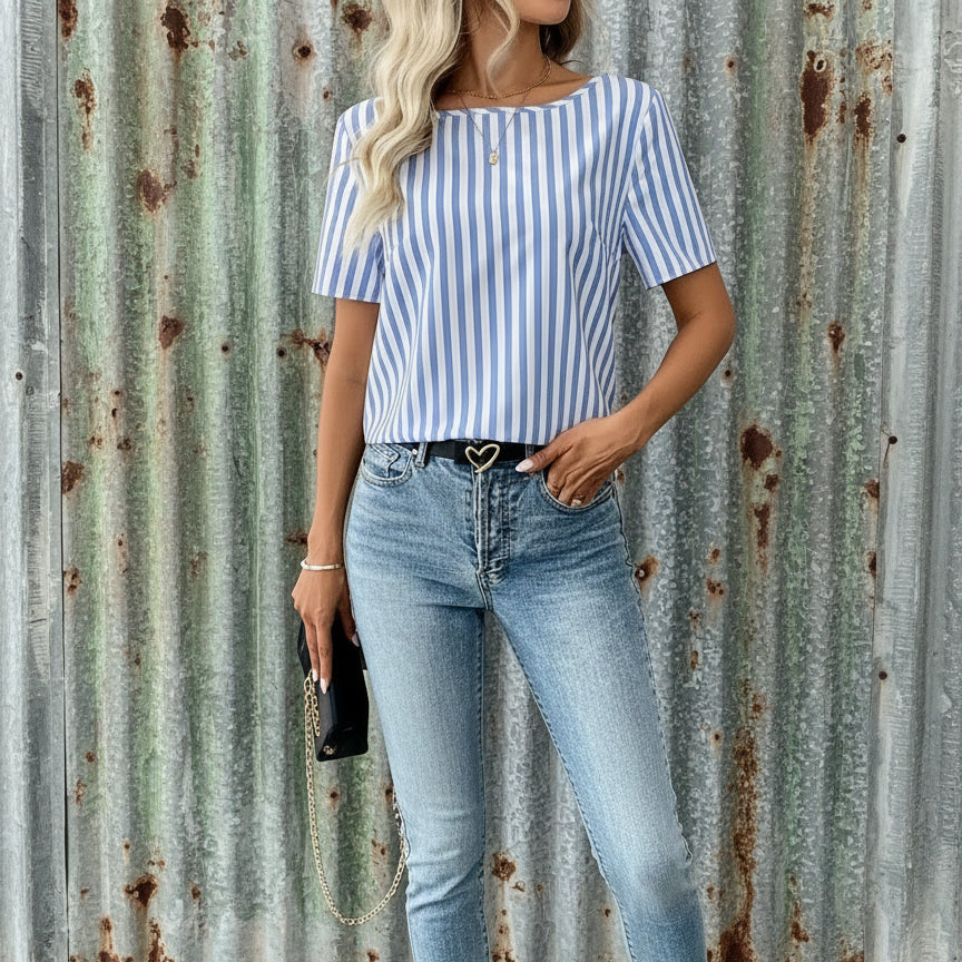 Person wearing a blue and white striped shirt and jeans indoors.