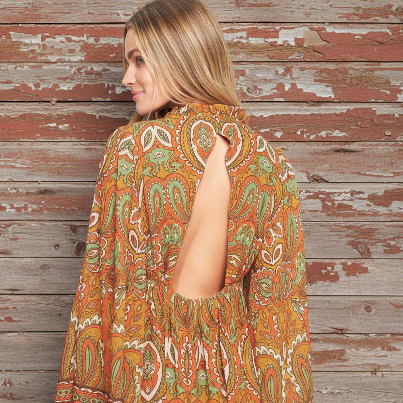 Woman wearing a patterned dress with a plain background