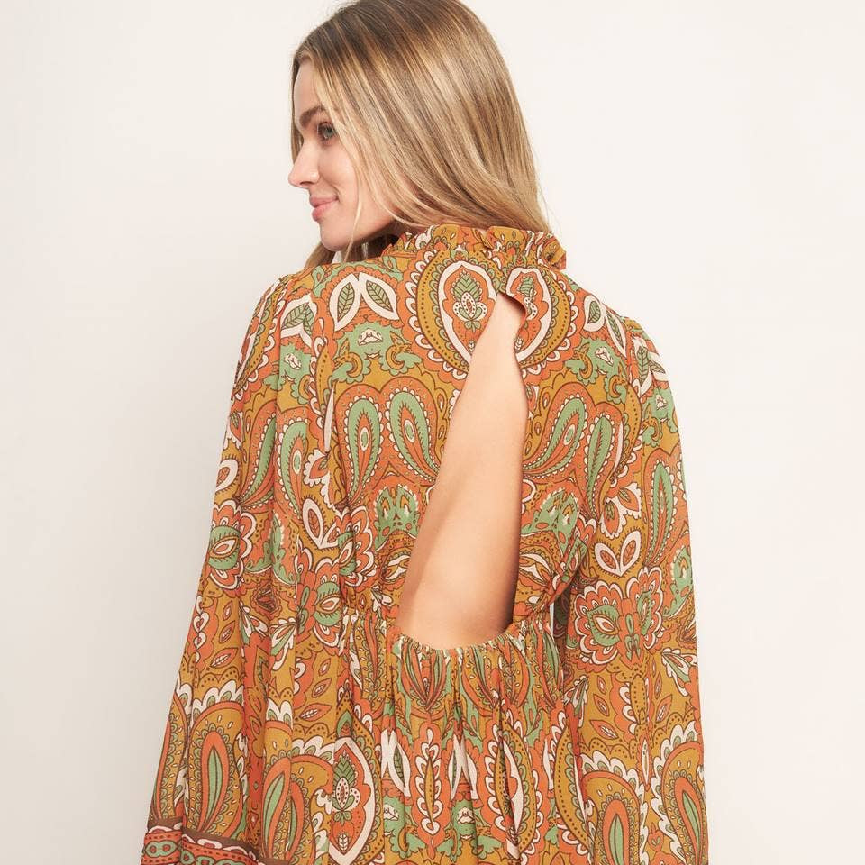 Woman wearing a patterned dress with a plain background