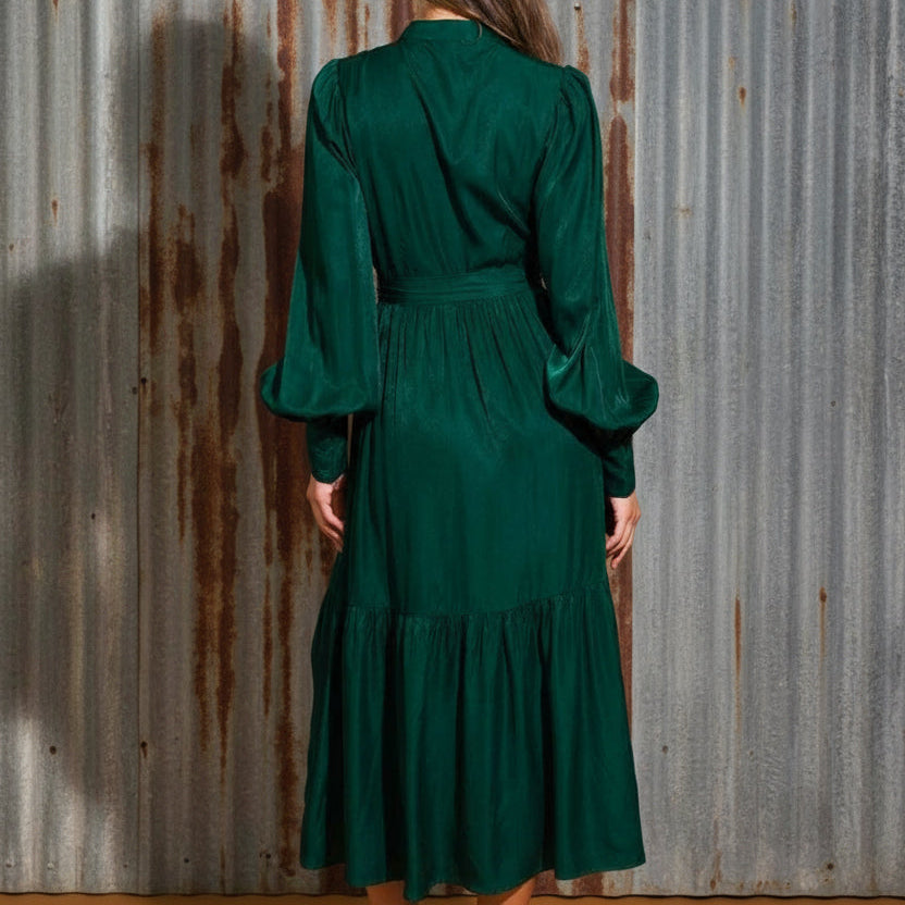 Woman wearing a green dress against a brown background