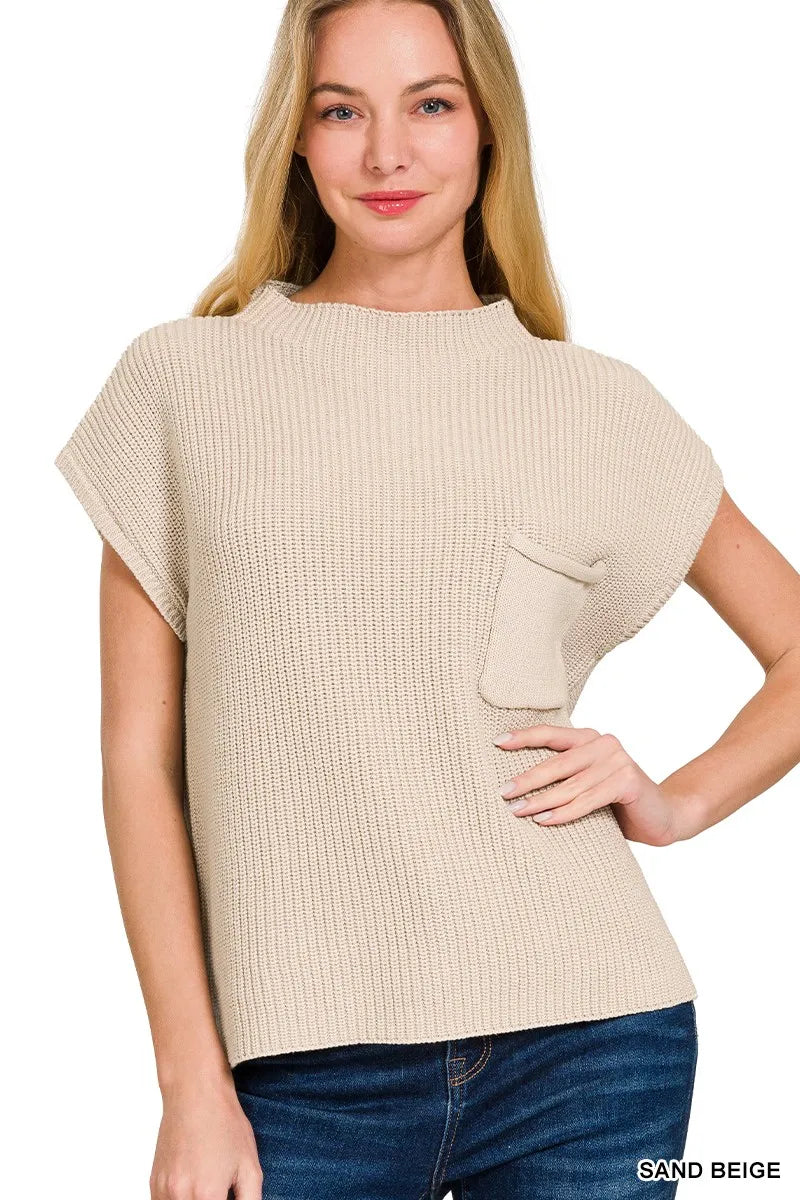 Woman wearing a sand beige sweater with a plain background