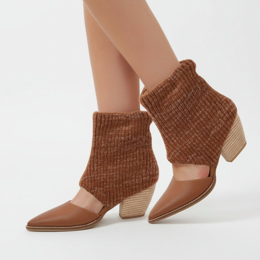 Brown ankle boots worn with a neutral background