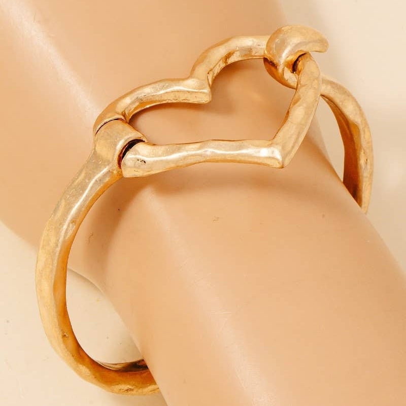 Gold bracelet with a unique design on a mannequin arm against a beige background
