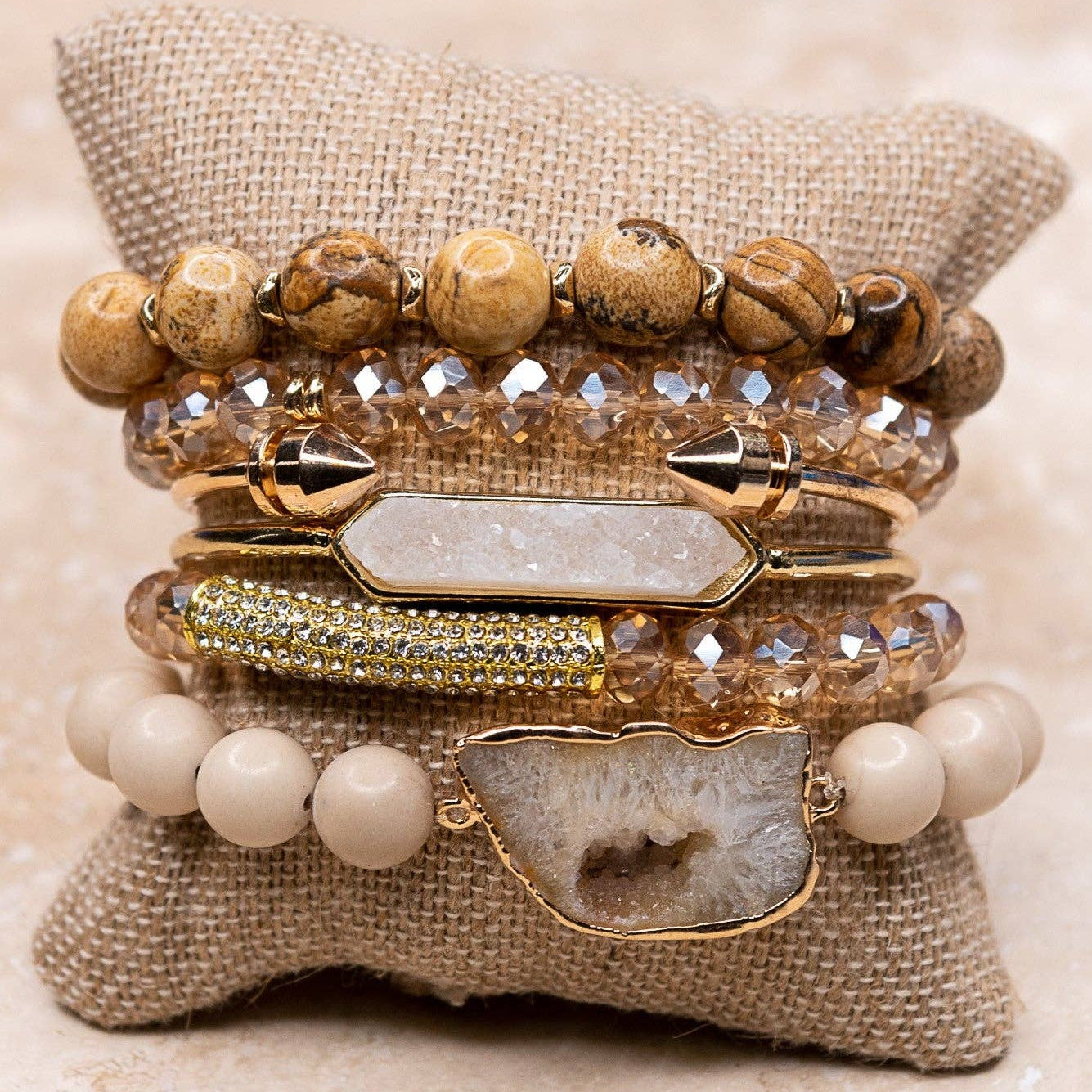 Stack of bracelets on a textured beige pillow