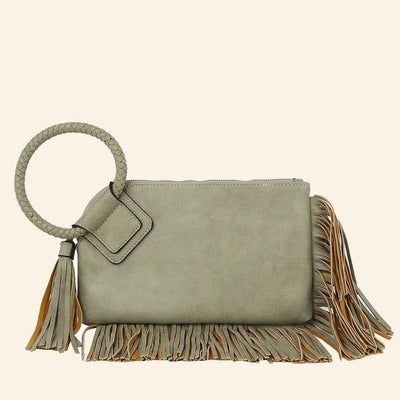 Green handbag with fringe details on a beige background