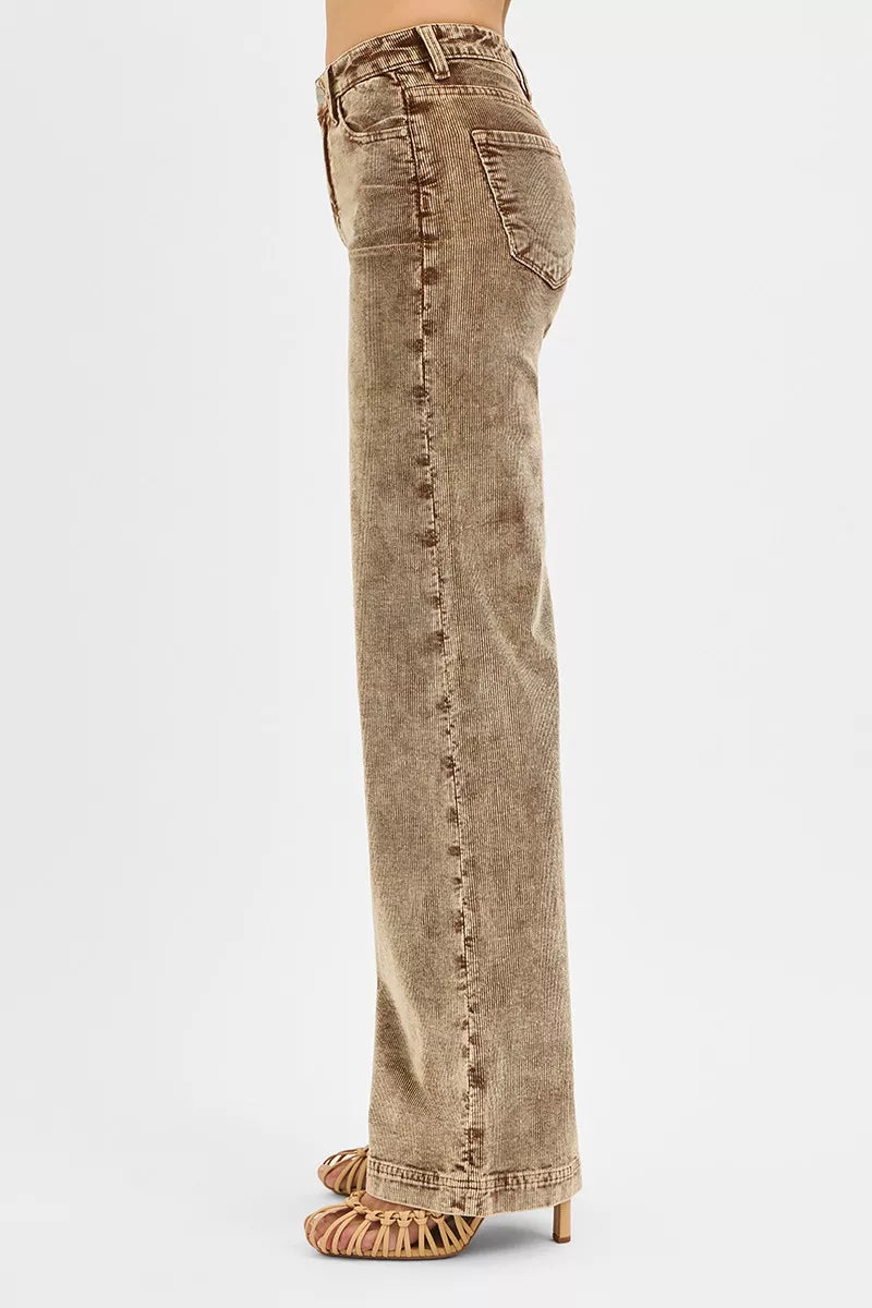 Brown corduroy pants worn by a person on a white background