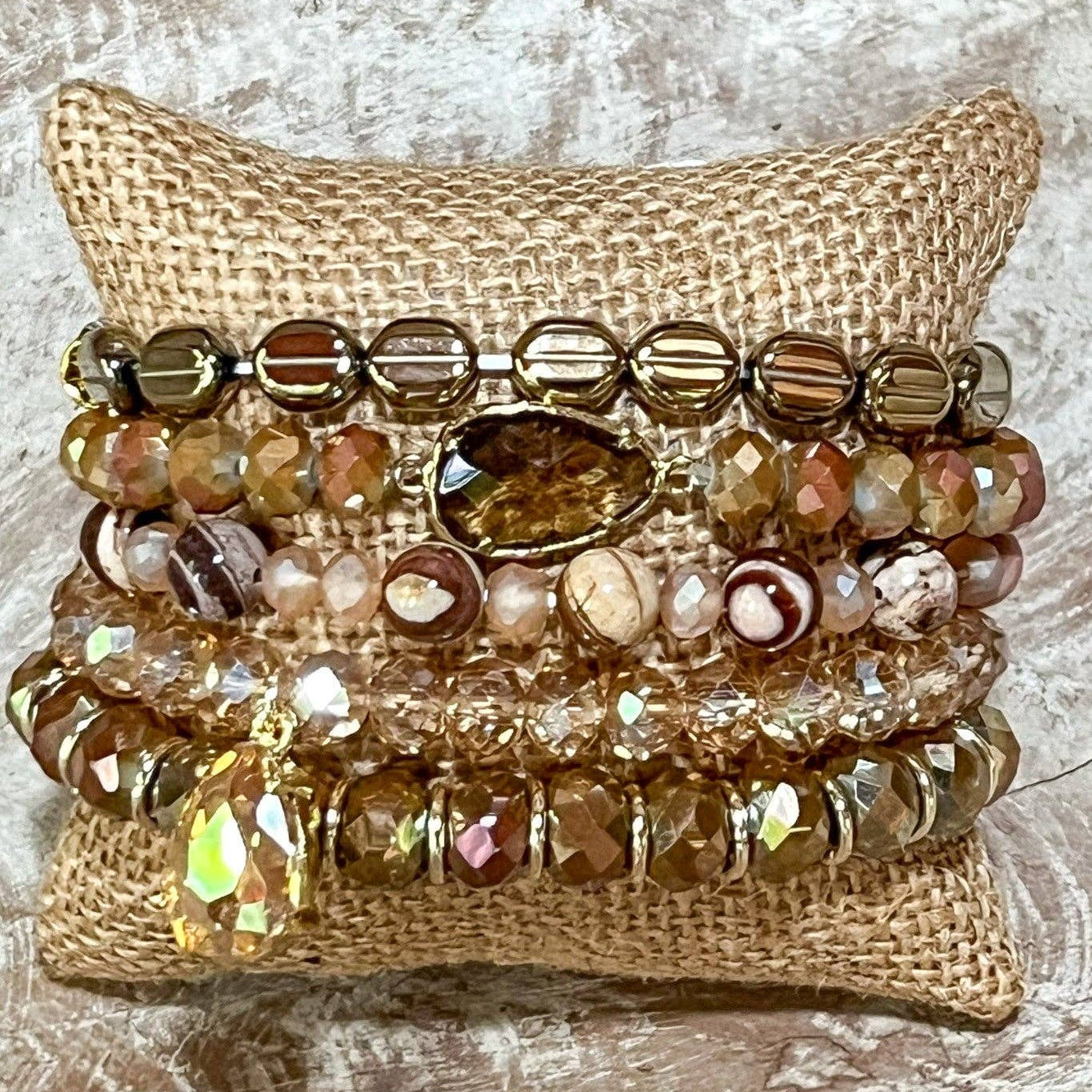 Stack of beaded bracelets on a textured surface