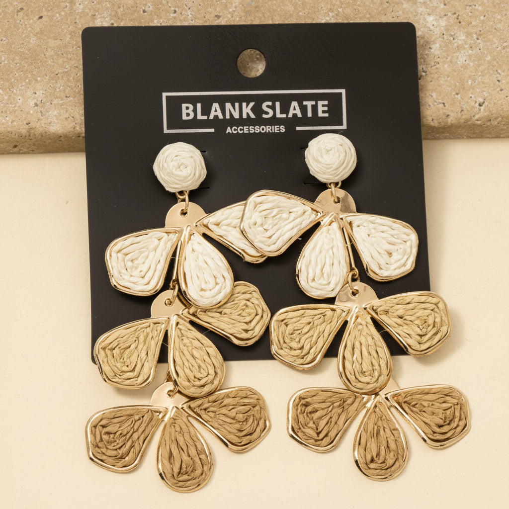 Gold earrings on a 'Blank Slate Accessories' card against a beige background
