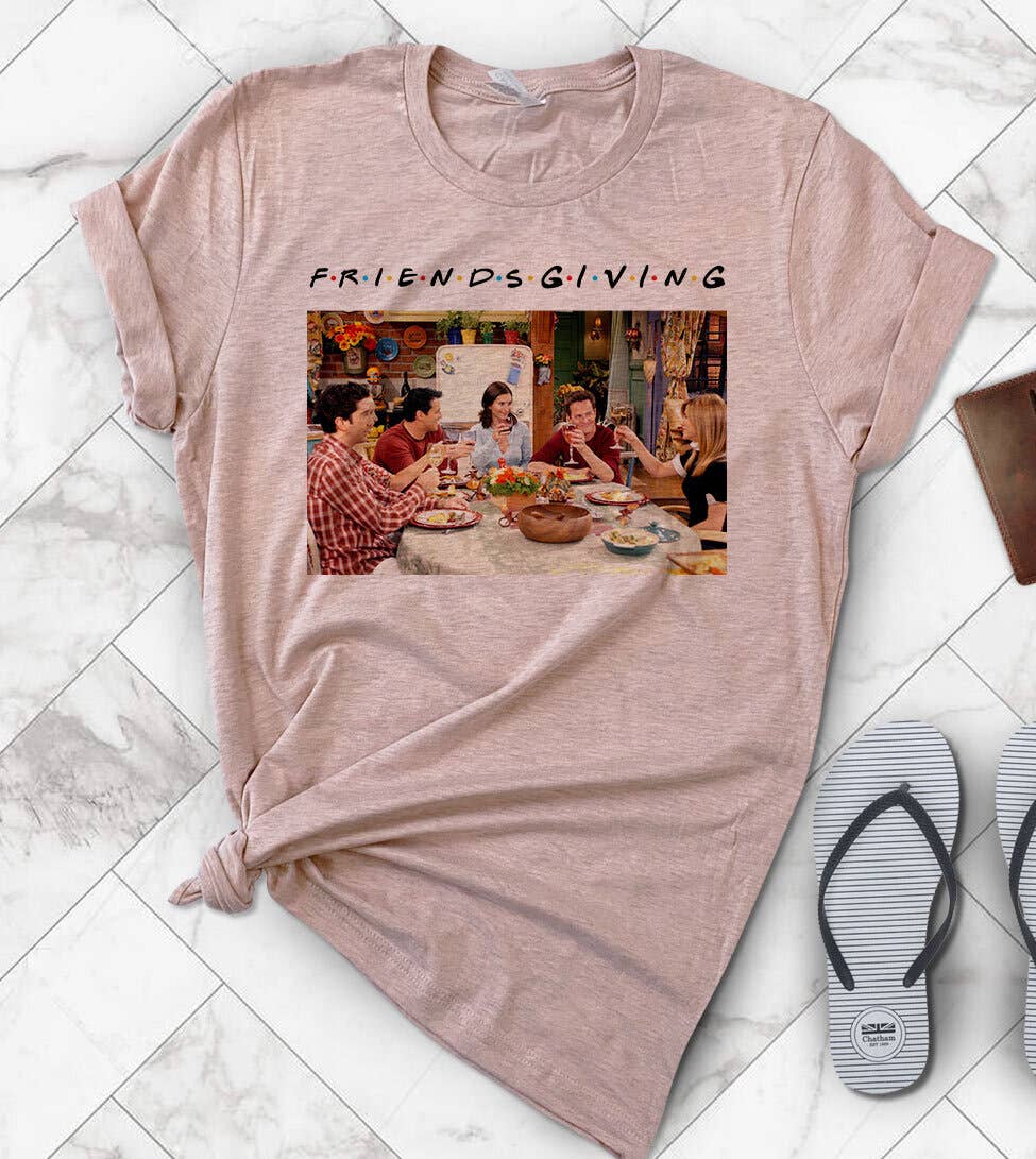 Pink t-shirt with 'Friendsgiving' graphic on a marble floor