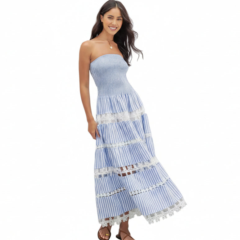 Woman wearing a blue and white striped dress with lace details on a white background