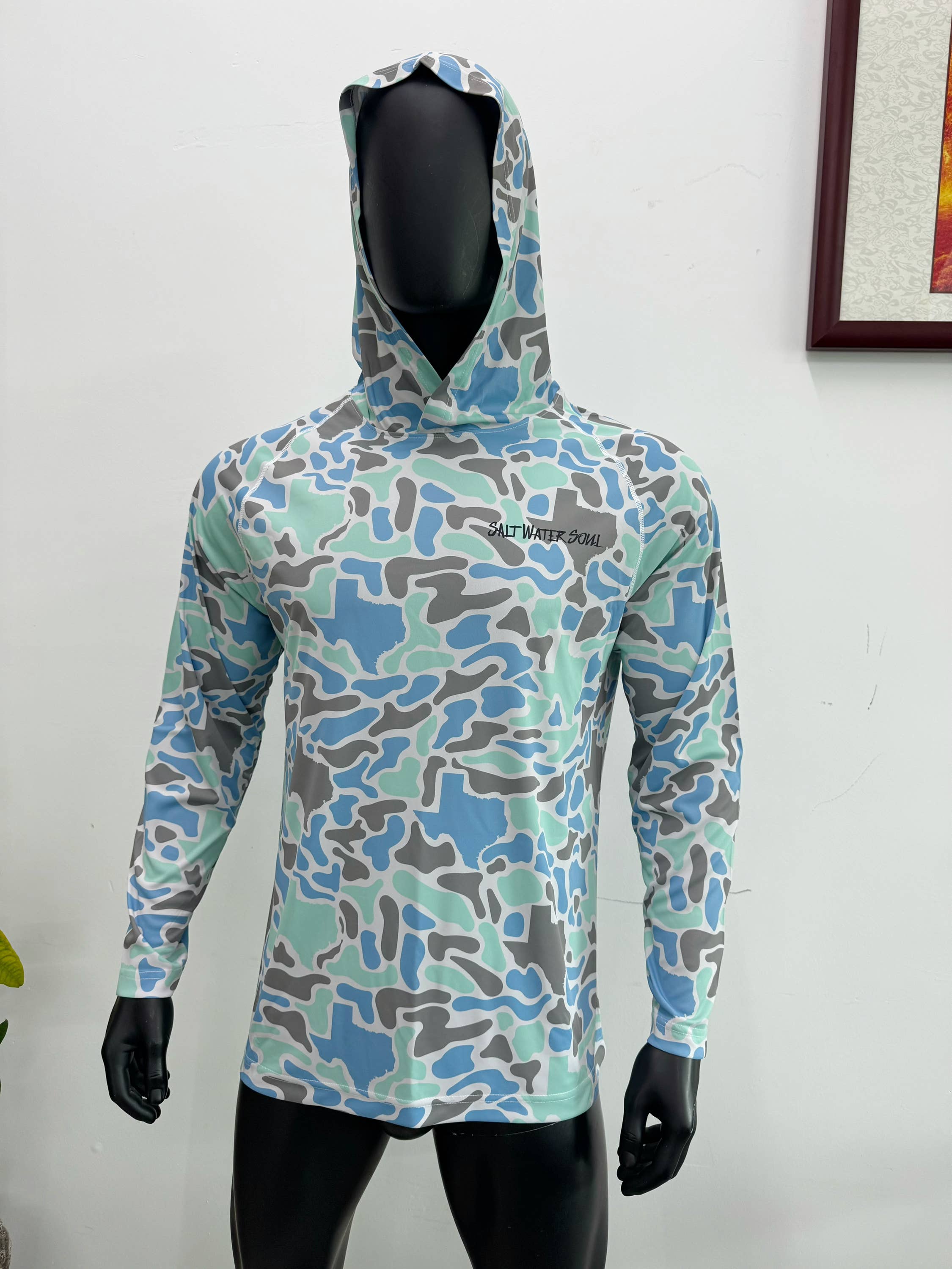 Camouflage-patterned hoodie on a mannequin against a white background