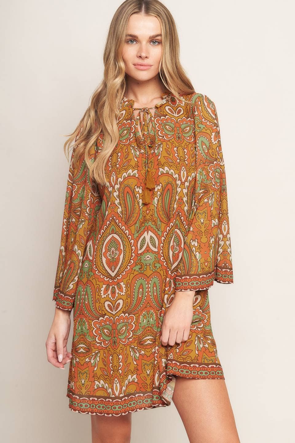 Woman wearing a patterned dress on a plain background