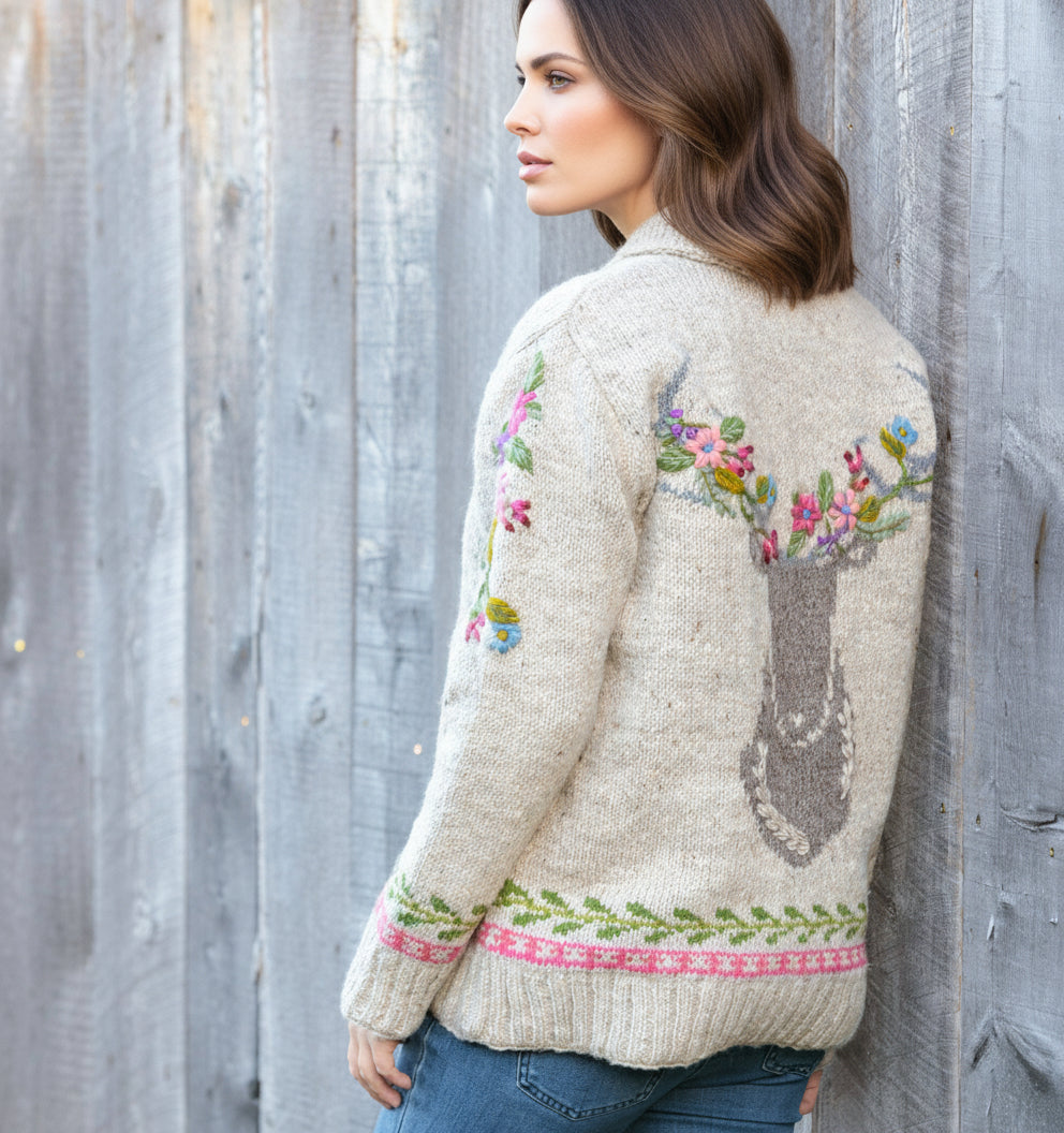 Woman wearing a floral embroidered sweater against a wooden fence.
