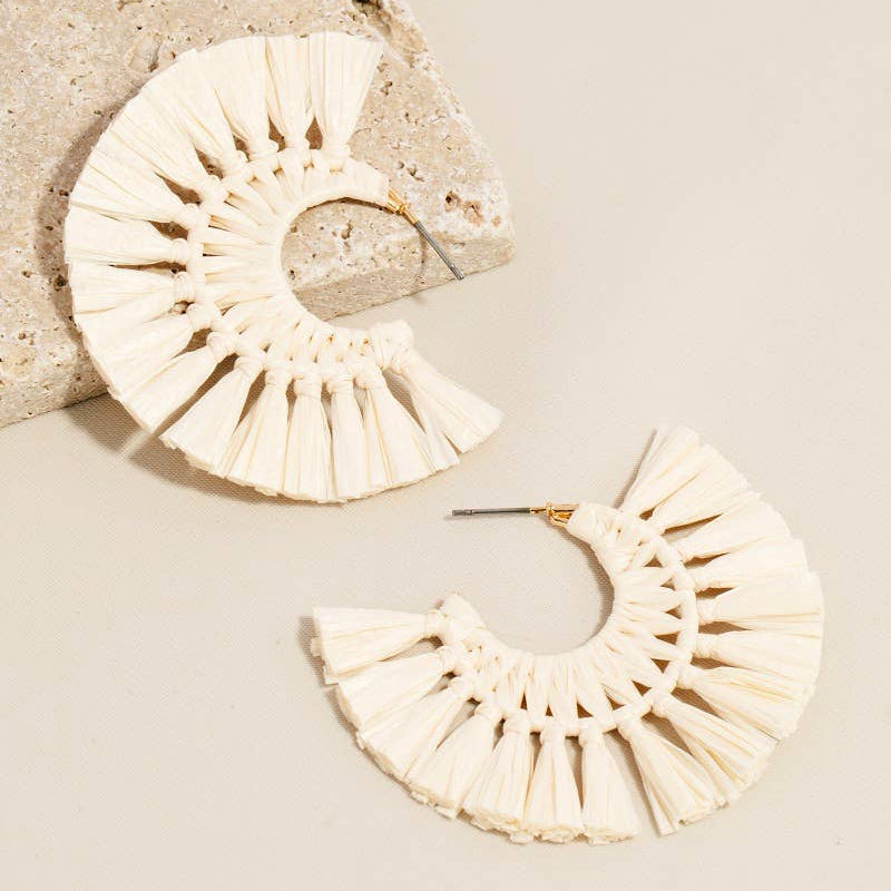 Beige raffia earrings on a beige background