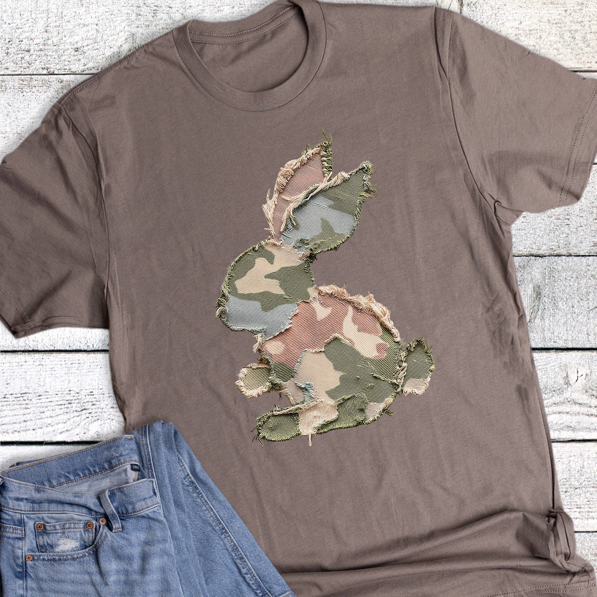 Brown t-shirt with a camouflage bunny design on a wooden surface
