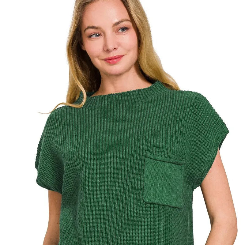 Woman wearing a green knitted top with a pocket on a white background