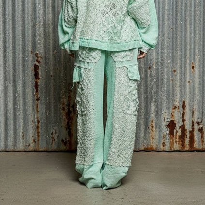 Mint green embroidered traditional outfit on a plain background