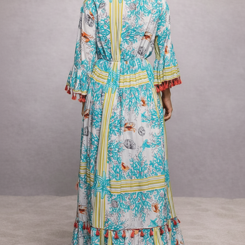 Woman wearing a colorful dress with a pattern, standing against a plain background