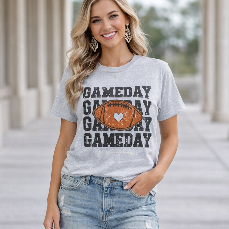 Woman wearing a 'GAMEDAY' t-shirt with a football graphic, standing on a stone pathway.