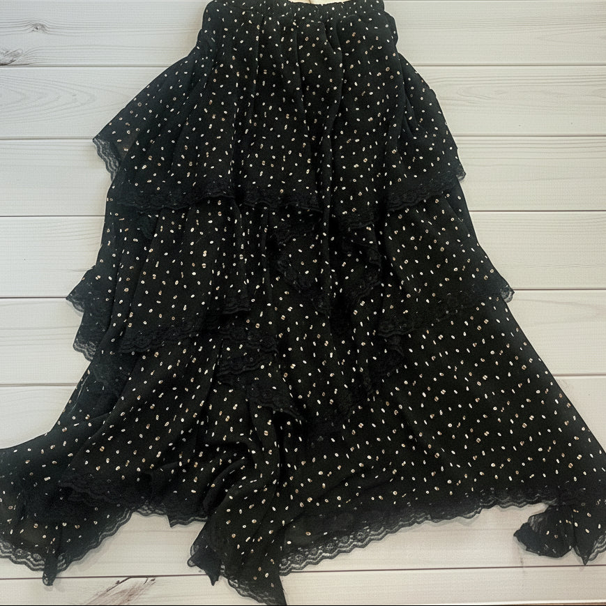 Black beaded top and beige t-shirt on a wooden floor