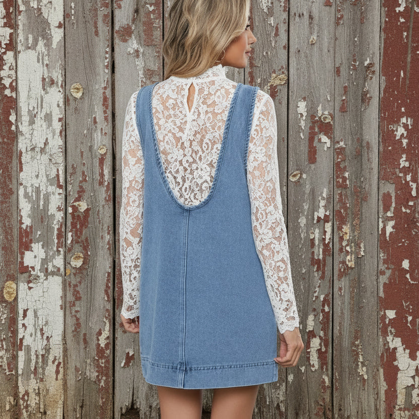 Woman wearing a denim dress with a white bra underneath, standing outdoors.