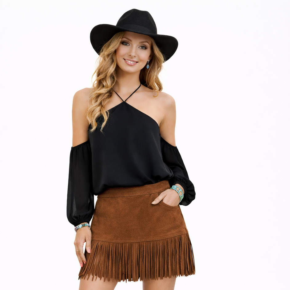 Woman wearing a black top, brown fringed skirt, and black boots on a white background