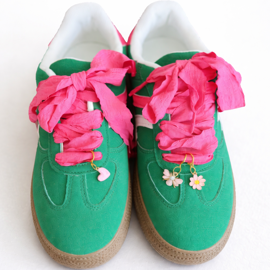 Green sneakers with pink laces on a white background