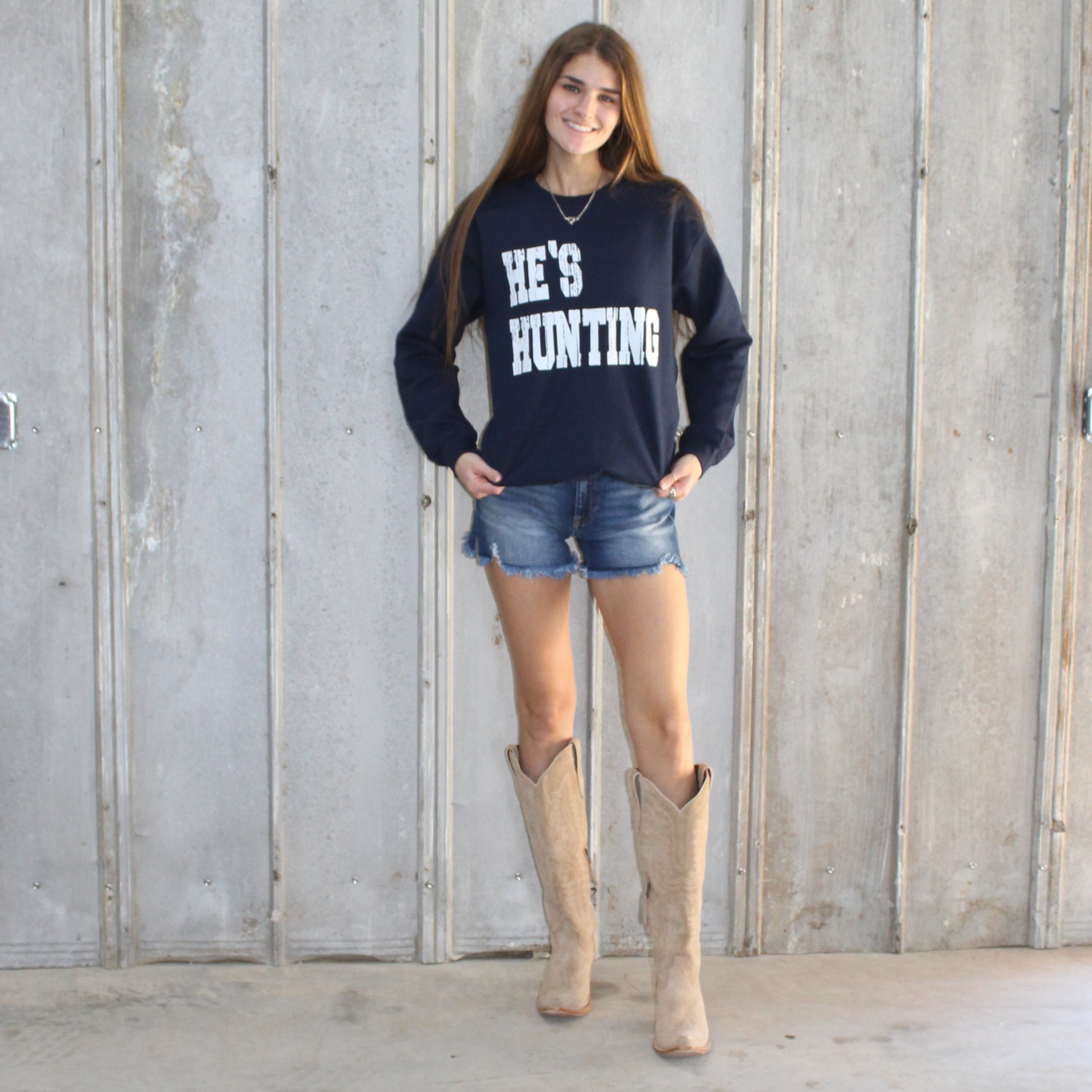 Person standing in a narrow alleyway between wooden and concrete walls