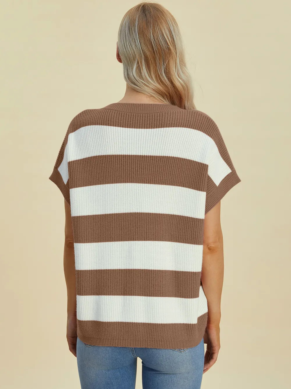 Woman wearing a brown and white striped sweater against a beige background