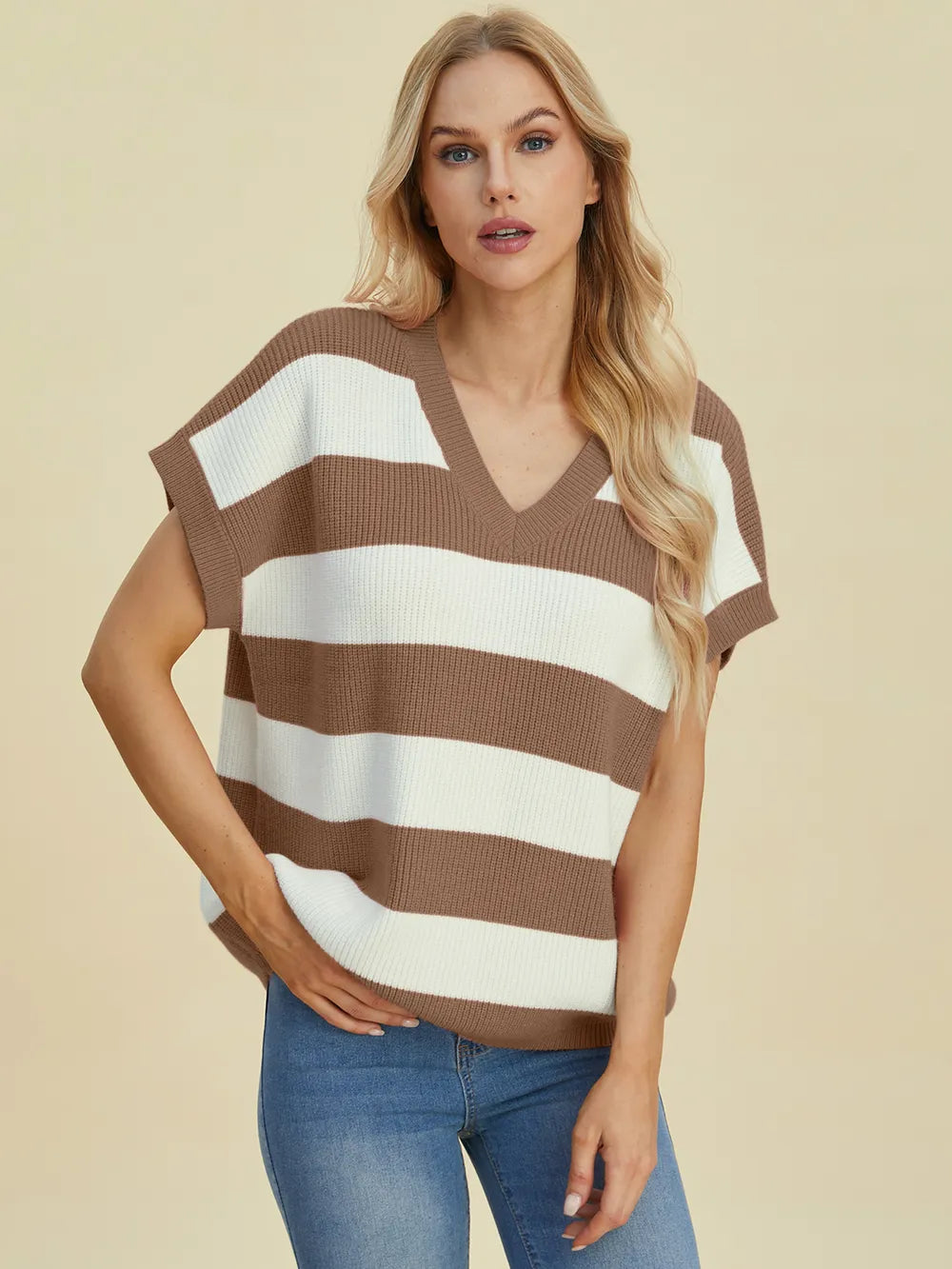 Woman wearing a brown and white striped sweater against a beige background