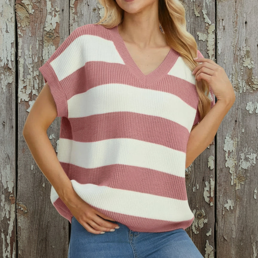 Woman wearing a pink and white striped sweater against a beige background