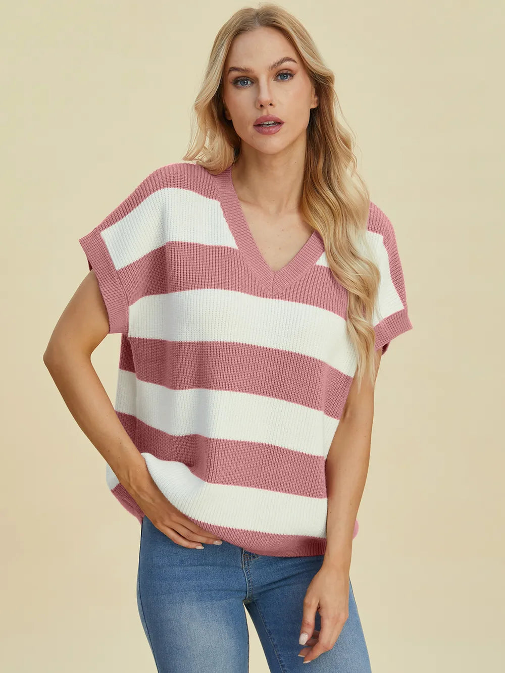 Woman wearing a striped sweater and jeans on a beige background