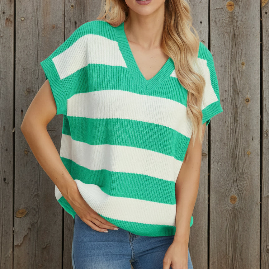 Woman wearing a green and white striped sweater against a beige background