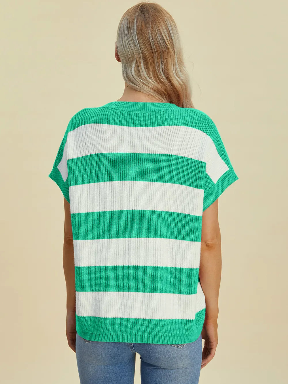 Green and white striped shirt worn by a person on a beige background
