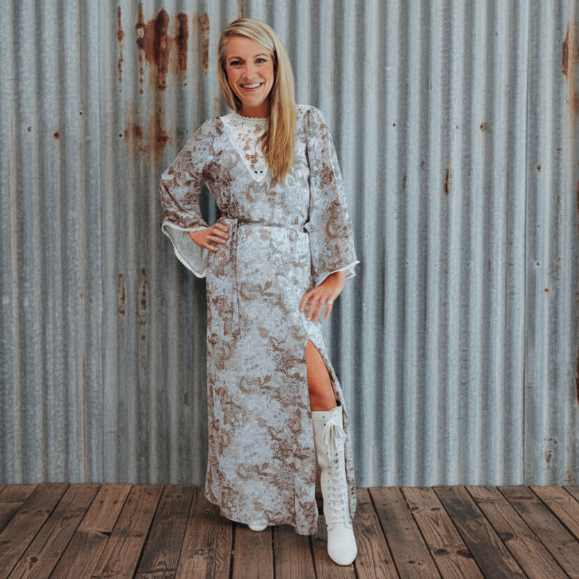 Woman in a floral dress with a high slit standing indoors.