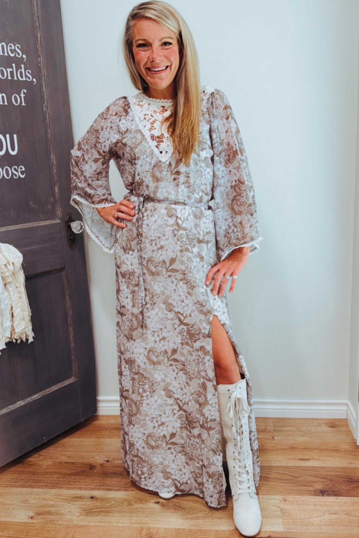 Woman in a floral dress with a high slit standing indoors.
