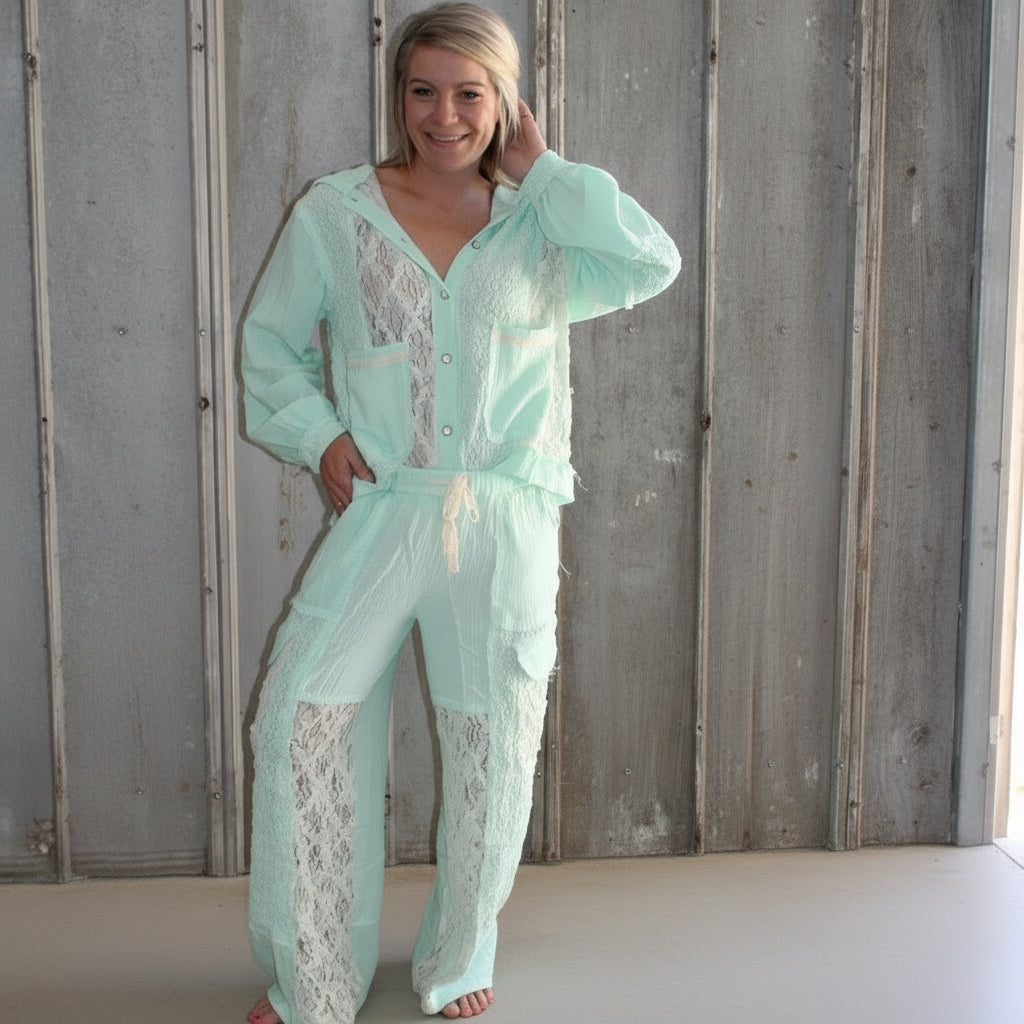 Person wearing a light blue lace outfit standing on a set of stairs.