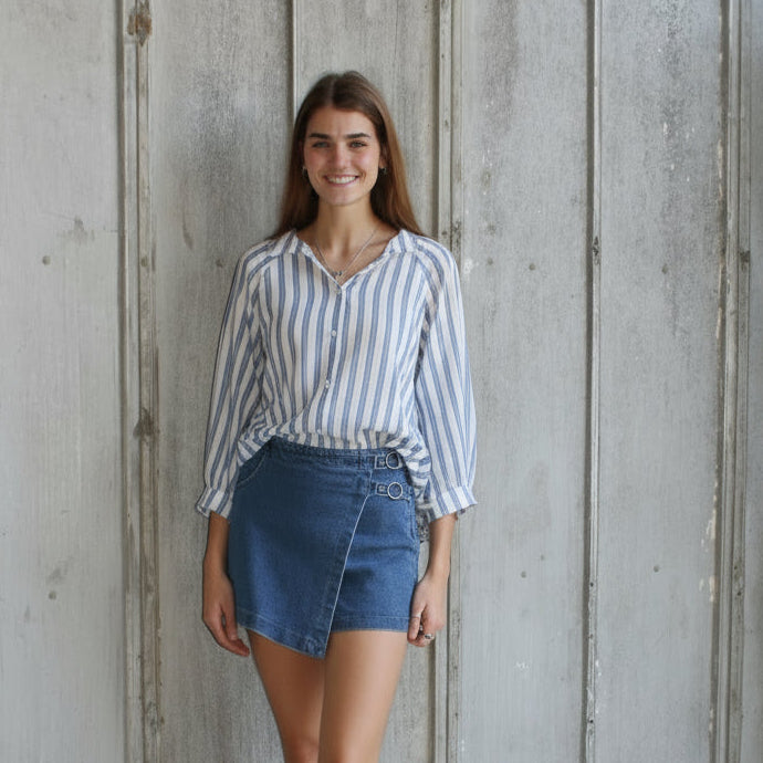 Woman standing on a wooden floor with a textured wall in the background