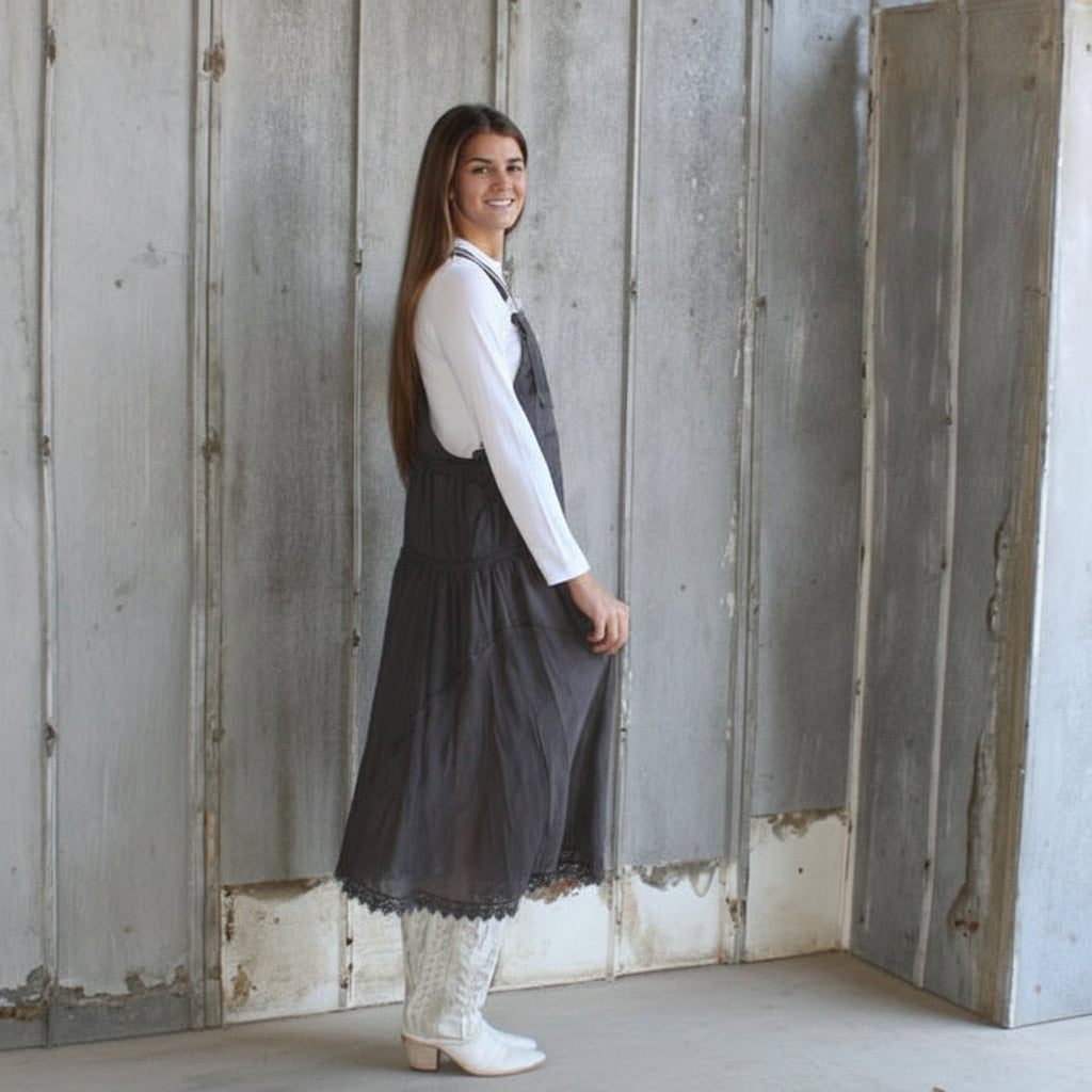 Woman standing in a room with unfinished walls and floor.