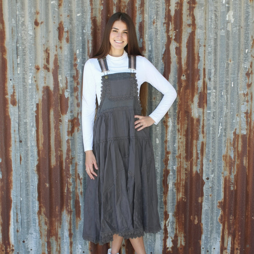 Person wearing a white sweater and brown dress on a brick pavement
