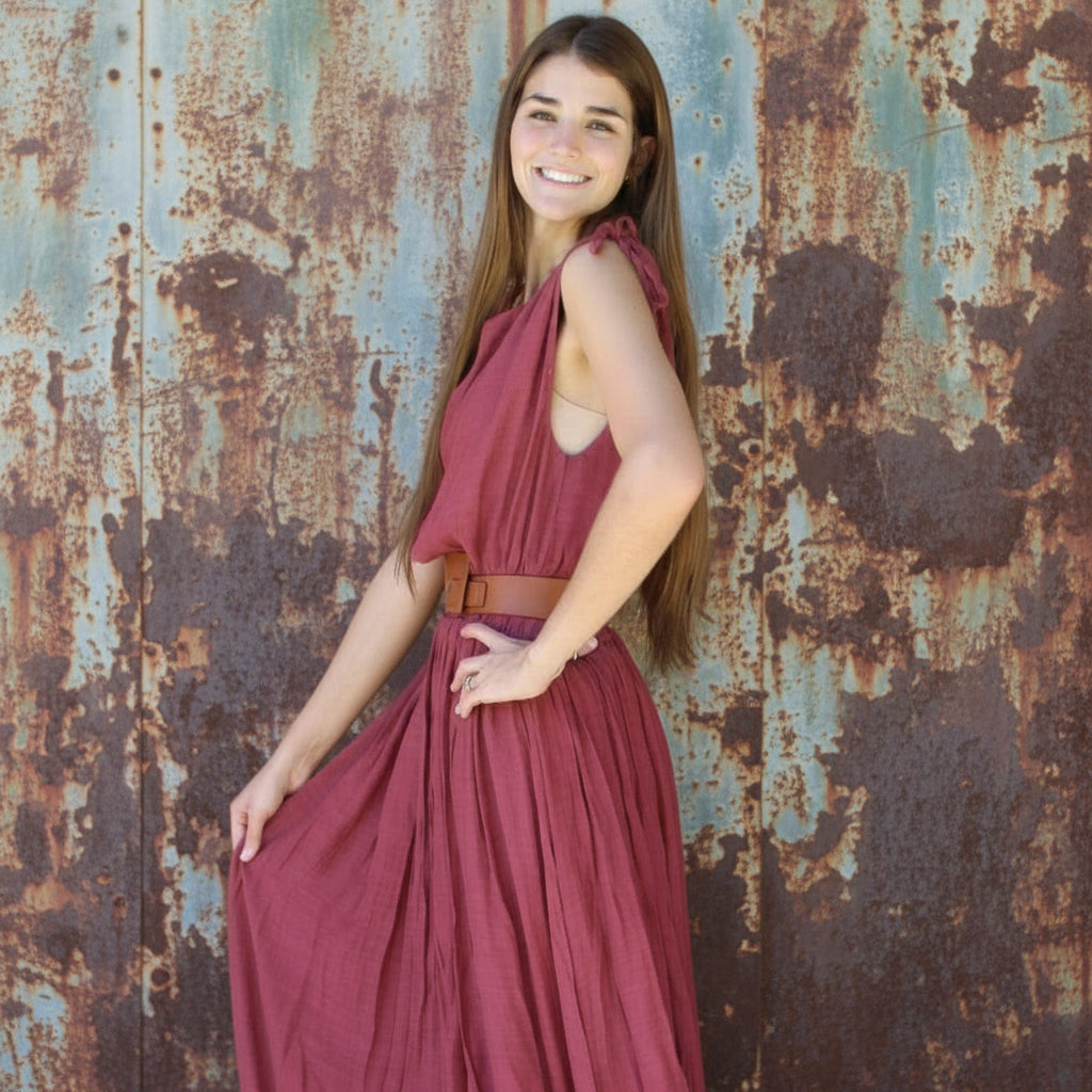 Woman in a red dress standing on a brick pavement