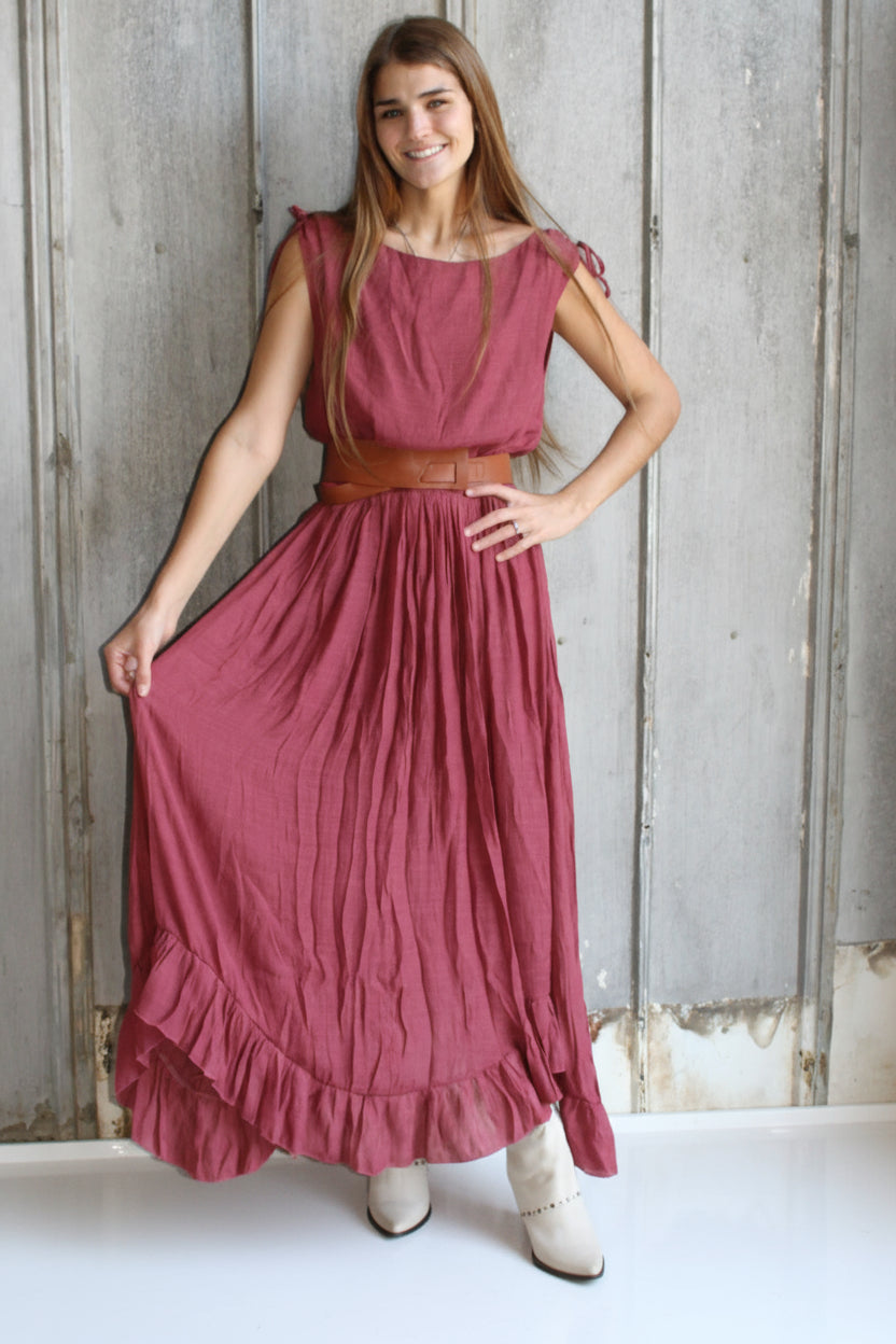 Woman in a red dress standing on a textured floor.