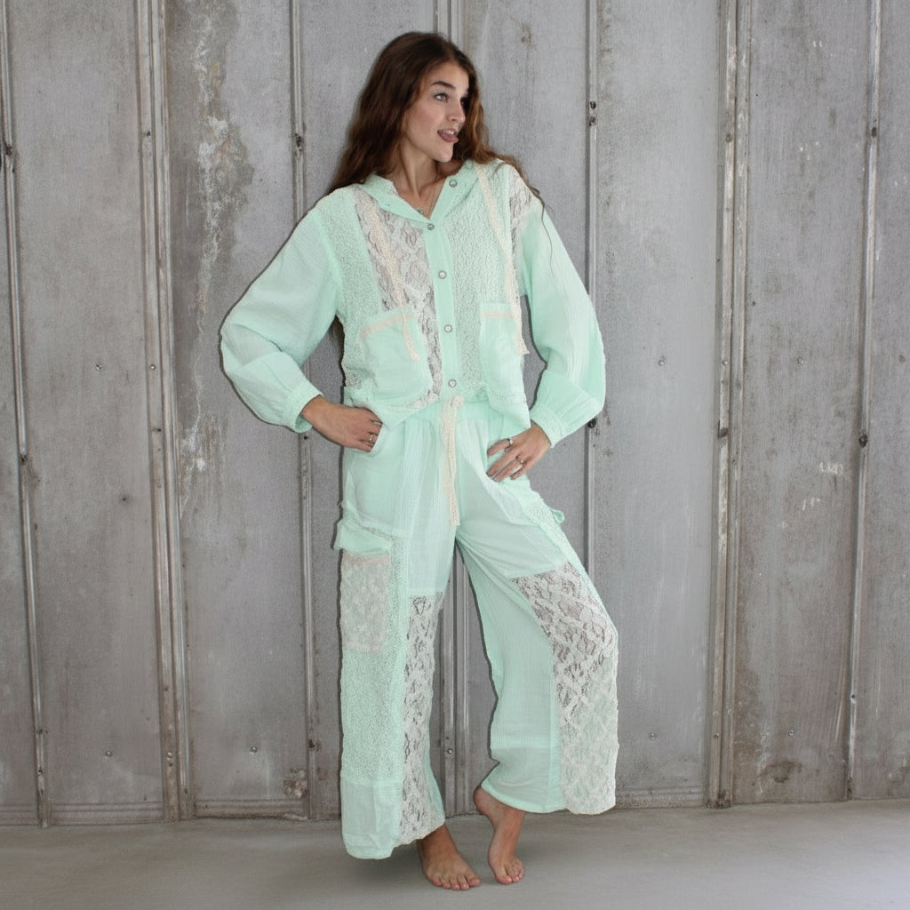 Person wearing a light green outfit lying on a wooden floor.