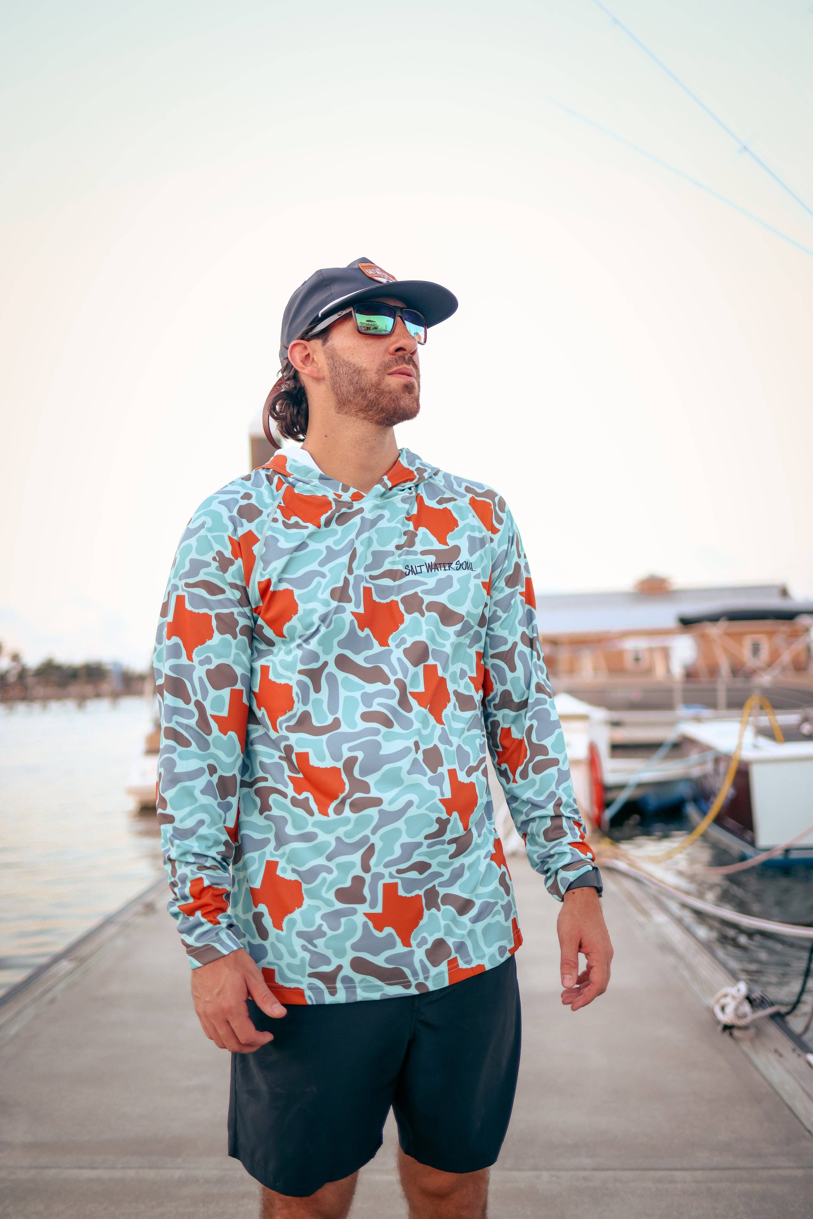 Man wearing a colorful long-sleeve shirt with Texas design on a dock.
