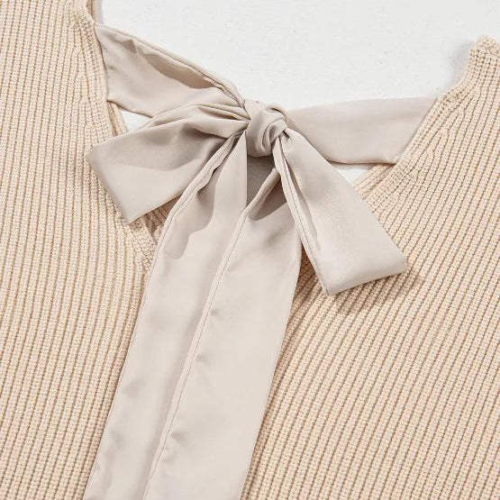 Beige ribbed sweater with a large bow detail on a light background