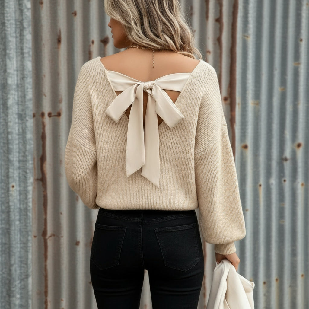Beige sweater with a bow detail on the back, worn by a person.