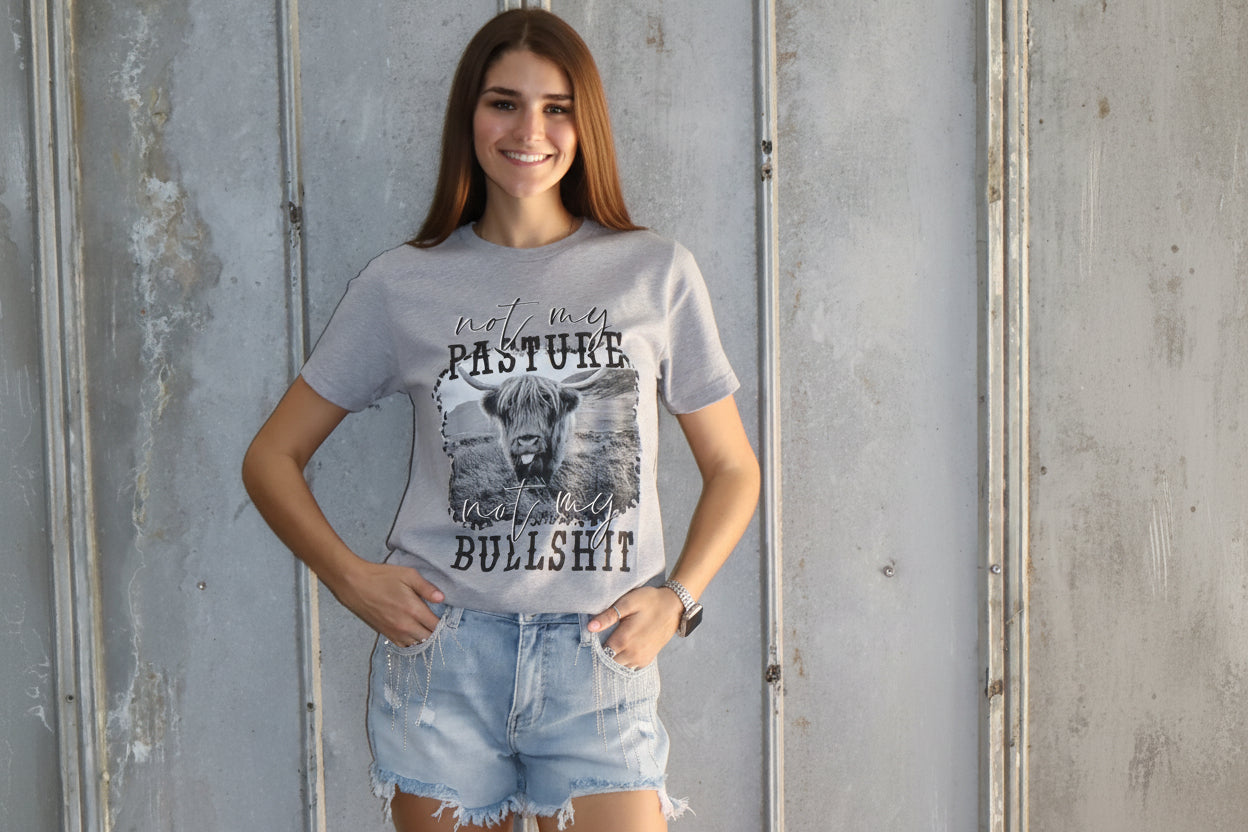 Person wearing a graphic t-shirt, denim shorts, and brown boots standing on a metallic surface.