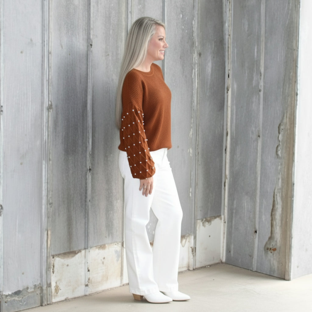 Person lying on a wooden deck with a white wall and steps in the background