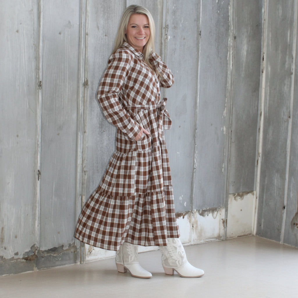 Person lying on a wooden deck with a checkered dress, surrounded by concrete walls.