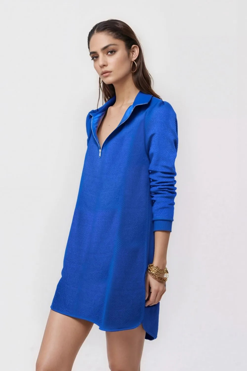 Woman wearing a blue dress against a white background